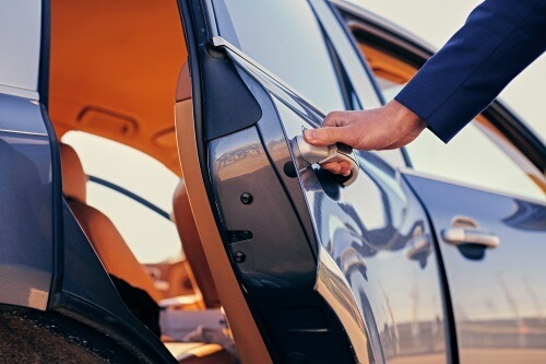 Chauffeur opens door for client in Glendale AZ